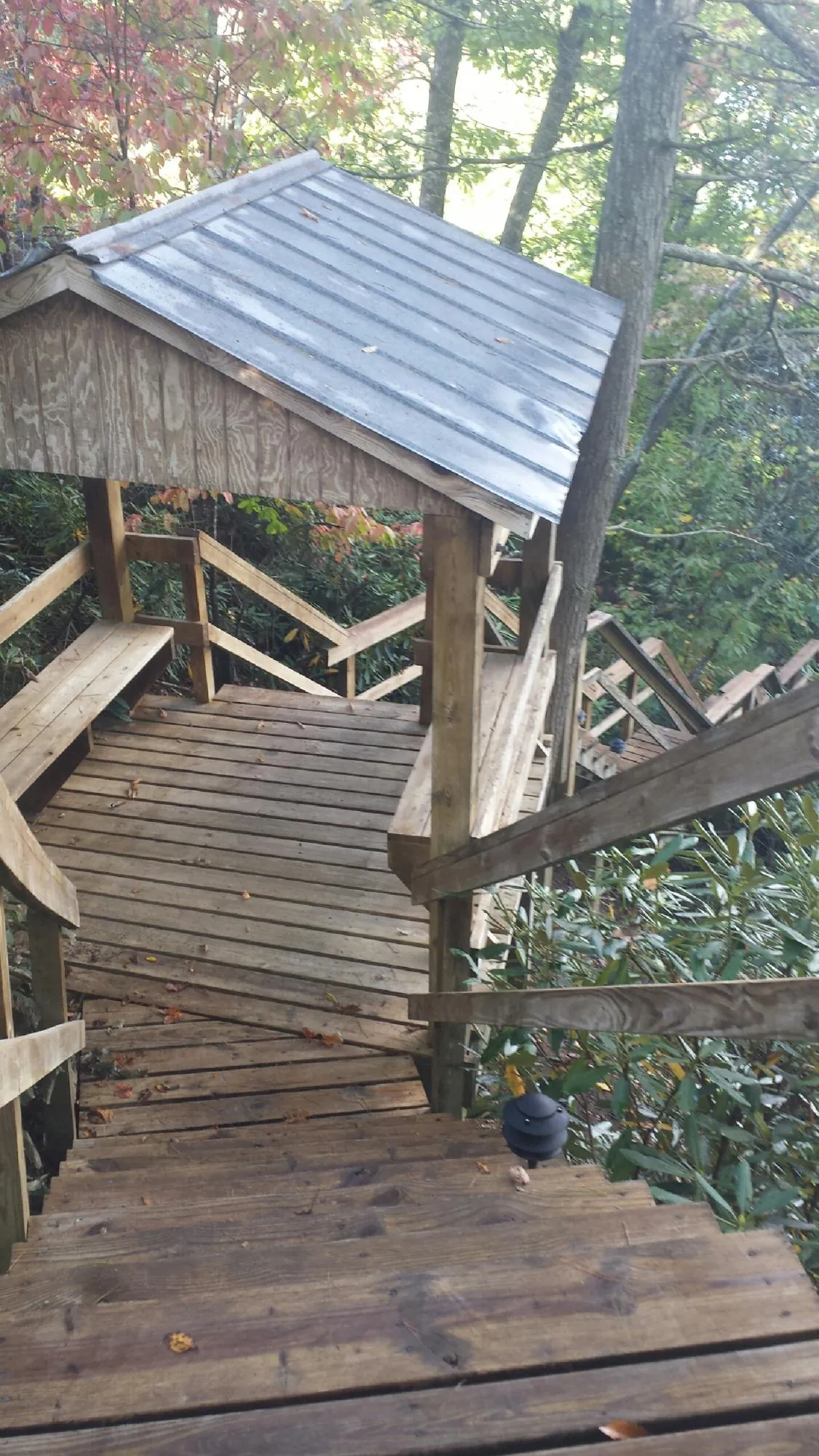 Metal roofed shelter over wooden steps on a wooded walkway — Skylight Repair & Installation work by our crew in Holland